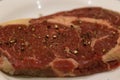 Close up of a seasoned raw rib eye steak