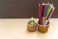 Close up seedling plant of Orange Jessamine  in pot with pencil on wooden background Royalty Free Stock Photo