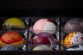 Close up of selection of colorful sweet delicious round shape chocolates in a box