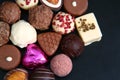 Close up of a selection of luxury chocolates, with a foil wrapped pink heart, which could be for a gift