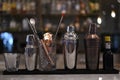 Close-up of a selection of metallic utensils for cocktail-making lined up in a row