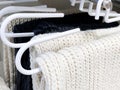 Close up of selection of soft knitted scarves in a clothing store retail low angle view.