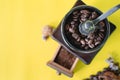 Close up selective coffee beans and grinned coffee bean in vintage wooden coffee grinder on yellow background