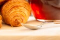 Close up and selective focus of Fresh croissants, spoon and honey jar over wooden board, breakfast, food background Royalty Free Stock Photo