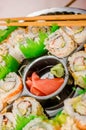 Close up of selective focus of large set of delicious japanese sushi rolls on a black plastic plate Royalty Free Stock Photo