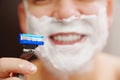 close-up. a man shaves with a safety razor with shaving foam. selective focus. Royalty Free Stock Photo