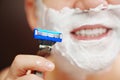 close-up. a man shaves with a safety razor with shaving foam. selective focus. Royalty Free Stock Photo
