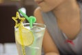 Close up and selective focus shot of lemonade soda in cocktail glass with fancy straw and lemon slice decoration in blurred