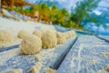 Close up of selective focus of small balls of sand after crabs lunch over a wooden structure in the beach of isla