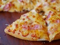 Selective focus of well-done fresh appetizing mushroom, ham, cheese pizza being served on a wooden tray, ready to eat