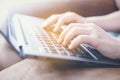 Close up and selective focus of woman`s hands, typing laptop keyboard and sitting on sofa Royalty Free Stock Photo