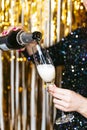 Close up. Selective focus. Woman serving a glass of champagne on New Year`s Eve. Background and close up New Year`s Eve concept