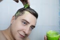 Man does head scrub. Dark-haired young man applies a scalp scrub to combat dandruff, oily scalp, alopecia. Problem skin causing