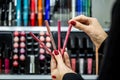 Close-up seller hands demonstrating different eyeliners in beauty store Royalty Free Stock Photo