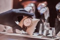 Close-up of the seller`s hand in gloves shows the exclusive men`s watch from the new collection Royalty Free Stock Photo