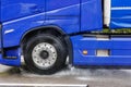 Close-up semi-trailer truck wheel driving fast Splashing Water on Highway, Risk of Aquaplaning on Wet Road. Detail view