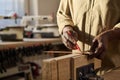 Close Up of Senior Carpenter Carefully Measuring Wood in Workshop Royalty Free Stock Photo