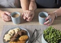 Close up of senior couple holding hands enjoying coffee and cookies Royalty Free Stock Photo