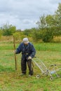 Close up of senior farmer using scythe to mow the lawn traditionally Royalty Free Stock Photo