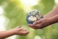 Close up of senior hands giving small planet earth to a child Royalty Free Stock Photo