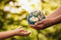 Senior hands giving planet earth to a child Royalty Free Stock Photo