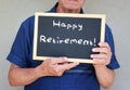 Close up of senior man holding blackboard with the phrase happy retirement written on it.