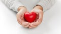 Close up of senior man holding red heart in hands Royalty Free Stock Photo