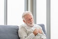 Close up of Senior man with pain on heart in living room, Mature man presses hand to chest has heart attack suffers from