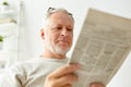 Close up of senior man reading newspaper at home Royalty Free Stock Photo