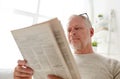 Close up of senior man reading newspaper at home Royalty Free Stock Photo