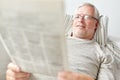 Close up of senior man reading newspaper at home Royalty Free Stock Photo