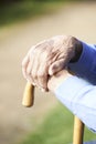 Close Up Of Senior Man's Hands Resting On Walking Stick