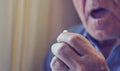 Close up of senior man taking medicine pill at home. Tinted photo Royalty Free Stock Photo