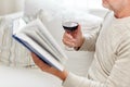 Close up of senior man with wine reading book Royalty Free Stock Photo