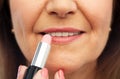 Close up of senior woman applying lipstick