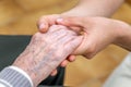 Close-up senior woman hand with her caregiver helping hands holding together, Caregiver visit at home. Home health care Royalty Free Stock Photo