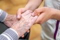 Close-up senior woman hand with her caregiver helping hands holding together, Caregiver visit at home. Home health care Royalty Free Stock Photo