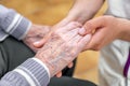 Close-up senior woman hand with her caregiver helping hands holding together, Caregiver visit at home. Home health care Royalty Free Stock Photo