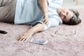 Close-up of senior woman with heart attack and smartphone on the