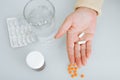 Close-up of senior woman holding two capsules of pills on palm of her hand indoors. Royalty Free Stock Photo