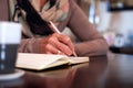 Close Up Of Senior Woman At Home Sitting At Table And Writing In Notebook Or Journal Royalty Free Stock Photo