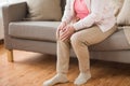 Close up of senior woman with pain in leg at home Royalty Free Stock Photo