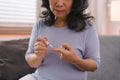 Close-up of a senior woman's hand checking her blood sugar level with a glucometer by herself at her home. Royalty Free Stock Photo