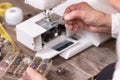 Close-up of senior woman seamstress hands removing the bobbin case in order to do the maintenance of a electrical sewing