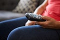 Close Up Of Senior Woman Sitting On Sofa Holding TV Remote