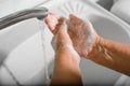 Close-up senior woman washes wrinkled hands with soap and foam in sink, disinfects from bacteria and viruses, top view. Royalty Free Stock Photo