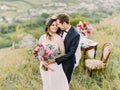Close-up sensitive portrait of the groom hugging the bride back in the mountains. Royalty Free Stock Photo