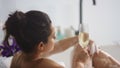 Sensual woman washing legs with foam in bathtub. Sexy girl drinking champagne