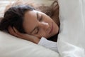 Close up serene beautiful woman sleeping under warm blanket alone