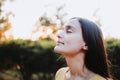 Close up of serene teenage girl with eyes closed connecting with nature at sunset in the park. Mental healing Royalty Free Stock Photo